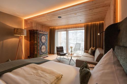 a bedroom with a bed and a living room at Sport-Wellnesshotel Bichlhof in Kitzbühel