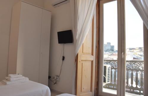 a bedroom with a bed and a balcony with a television at La Casa nel Borgo Antico in Melfi