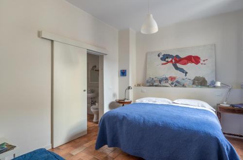 una camera da letto con un letto blu e un dipinto sul muro di B&B Giorni Dipinti a Firenze
