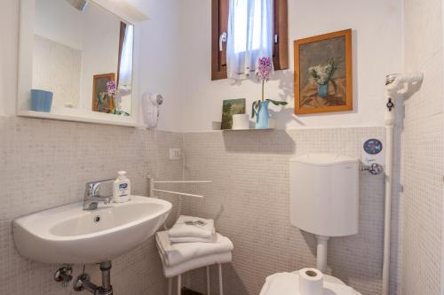 un bagno bianco con lavandino e WC di B&B Giorni Dipinti a Firenze