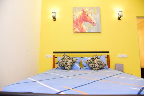 a bedroom with a bed with a painting of a horse at White Villa Airport Transit Hotel in Katunayake