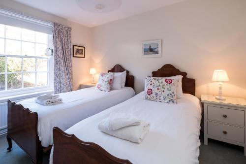 zwei Einzelbetten in einem Zimmer mit Fenster in der Unterkunft Pear Tree Cottage in Aldeburgh