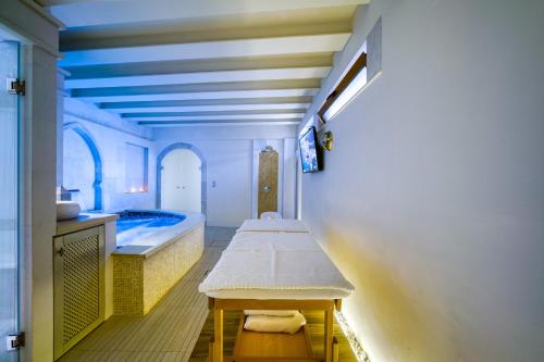a bathroom with a tub and a table in a room at Rozmari and Spa in Agia Galini