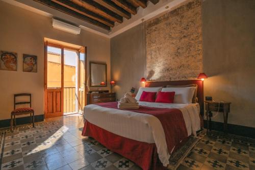 a bedroom with a large bed with red pillows at Cappuccine GuestHouse in Cagliari