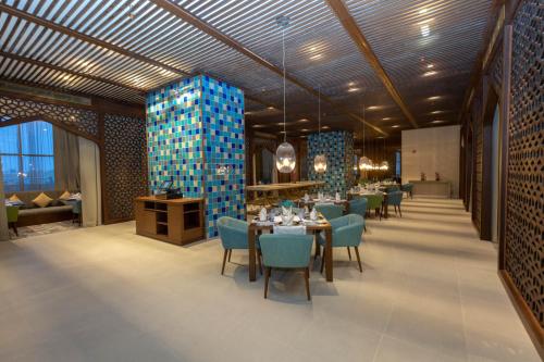 a dining room with a table and blue chairs at Tilal Riyadh in Riyadh