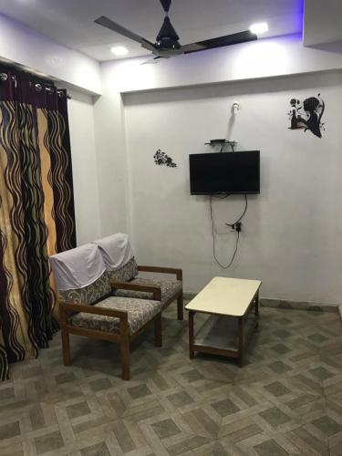 a room with a couch and a tv and a table at Hotel Hari darshan in Nāthdwāra