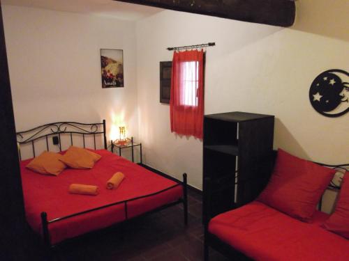 a bedroom with a red bed and a red chair at Fundalucia Guesthouse in Quéntar