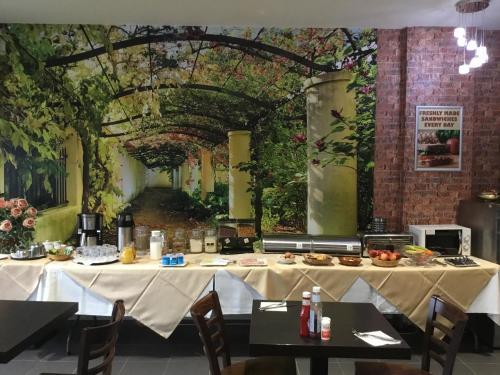 a dining room with a table with food on it at Star Anglia Hotel City Center by OYO in Colchester