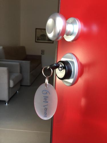 a red door with a key tag on it at B & b Venere in Paestum