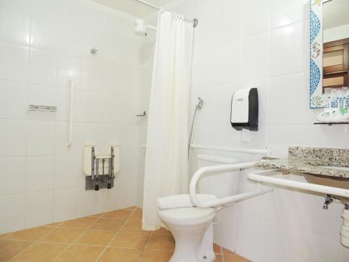 a white bathroom with a toilet and a shower at Pousada Mosaico Brasil - Maresias in Maresias