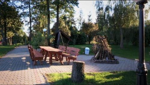 a picnic table and benches in a park at Pensjonat Teresa in Marcinowa Wola