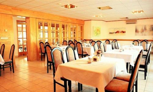 a restaurant with tables and chairs with white table cloth at Pensjonat Teresa in Marcinowa Wola