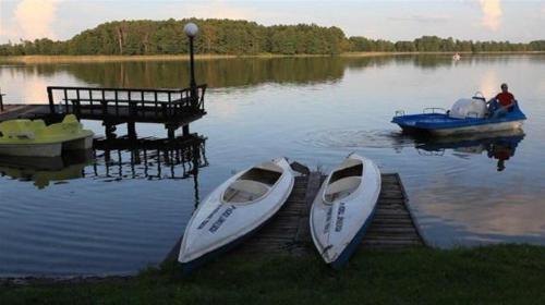 two boats are docked at a dock on a lake at Pensjonat Teresa in Marcinowa Wola