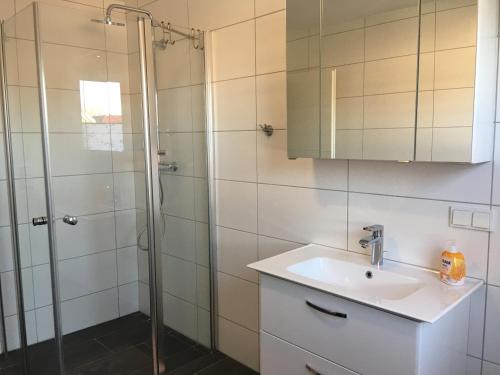 La salle de bains est pourvue d'un lavabo et d'une douche. dans l'établissement Ferienwohnung Krabbenkutter-Greetsiel, à Greetsiel