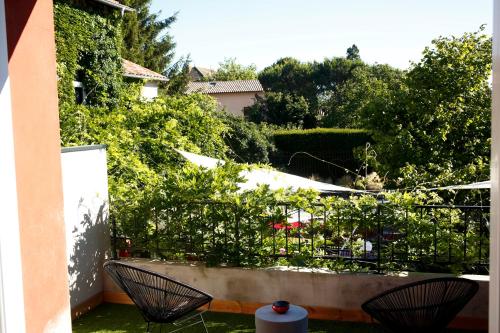 un patio con 2 sillas y un jardín en Auberge Du Paradis, en Saint-Amour-Bellevue