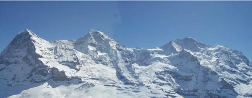 einen schneebedeckten Berg mit blauem Himmel im Hintergrund in der Unterkunft Chalet Unter dem Stein in Grindelwald