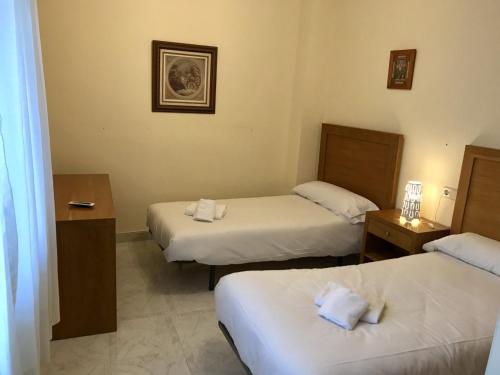 ein Hotelzimmer mit 2 Betten und Handtüchern darauf in der Unterkunft Apartamento Decada Reyes Catolicos in Fuengirola