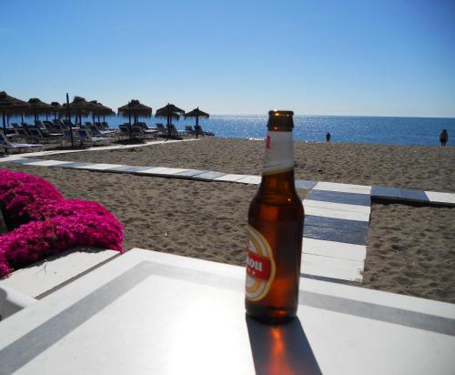 eine Flasche Bier auf einem Tisch am Strand in der Unterkunft Apartamento Decada Reyes Catolicos in Fuengirola
