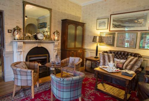 a living room filled with furniture and a fireplace at Raheen House Hotel in Clonmel