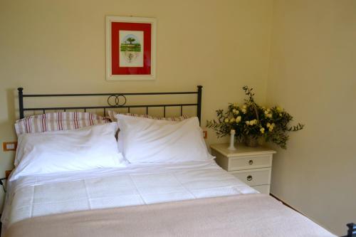a bed with white sheets and a plant on a night stand at Monte A Pescia in Pescia