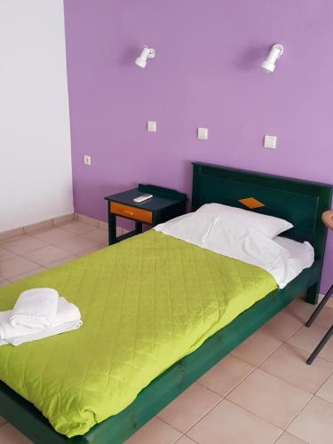 a bedroom with a green bed and a purple wall at Mikes Apartment in Georgioupolis
