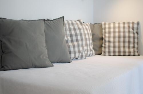 a group of pillows sitting on top of a bed at L’arco Milos Suite in Adamas