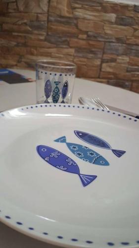 a plate with two fish painted on it on a table at Aligiò in Porto Torres