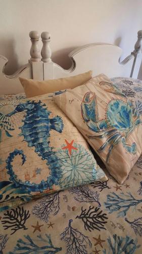 a bed with a comforter with a mermaid on it at Aligiò in Porto Torres