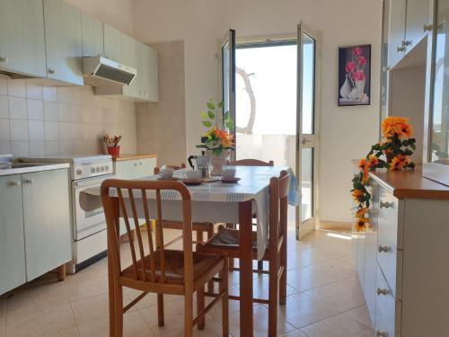 Appartamenti La Spiaggia في غالّيبولي: مطبخ مع طاولة وكراسي في مطبخ