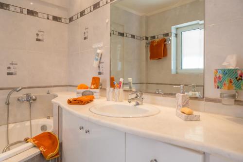 a bathroom with a sink and a mirror and a tub at Santa Barbara Garden and Pool Home in Marathón