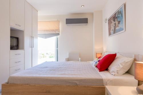 a white bedroom with a large bed with red pillows at Santa Barbara Garden and Pool Home in Marathón