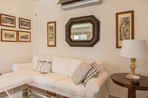 a living room with a white couch and a mirror at Santa Barbara Garden and Pool Home in Marathón