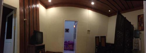 a room with a hallway with a television and a door at Bromo Deddy Homestay in Bromo