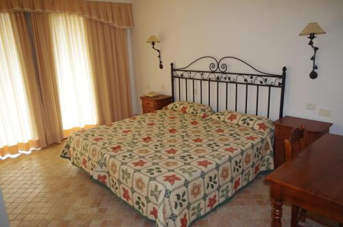 1 dormitorio con cama, mesa y ventanas en Apartamentos Playa de Los Roques en Los Realejos