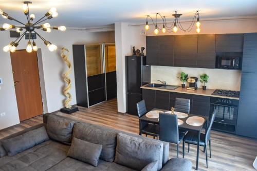 a kitchen and living room with a couch and a table at Wood Central Apartment in Timişoara