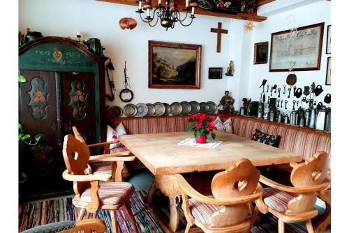 uma sala de jantar com uma mesa de madeira e cadeiras em Pension Charlotte em Bad Gastein