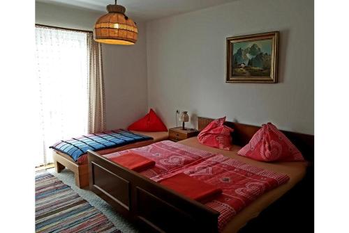 um quarto com 2 camas e almofadas vermelhas em Pension Charlotte em Bad Gastein