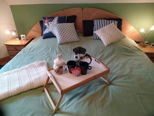 Una cama con una bandeja de té. en Ferienwohnung Spatzennest, en Wesel
