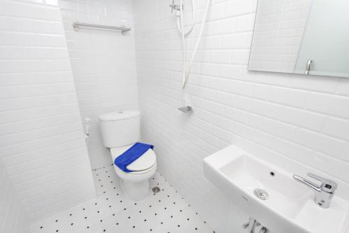 a white bathroom with a toilet and a sink at New Star in Pattaya Central