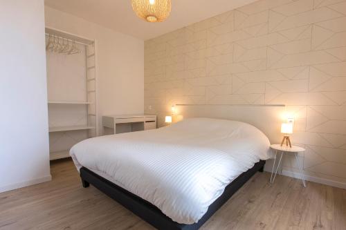 1 dormitorio con 1 cama blanca y 2 mesas con lámparas en Appart So Good Proche Gare et Tramway Balcon - Leenhardt 2, en Montpellier