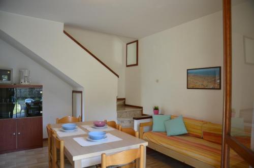een woonkamer met een tafel en een bank bij Ville Carla e Caterina in Bibione