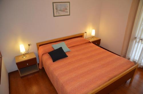 een slaapkamer met een bed met twee nachtkastjes en twee lampen bij Ville Carla e Caterina in Bibione