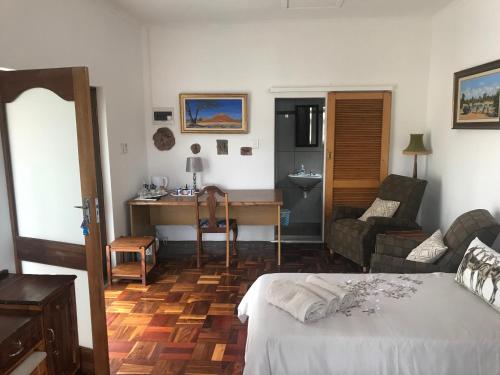 a bedroom with a bed and a desk and a couch at Towerzicht Guest House in Ladismith