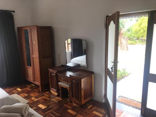 a room with a wooden dresser and a mirror at Towerzicht Guest House in Ladismith