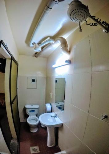 a bathroom with a white toilet and a sink at Residencial Uruguay in La Paz