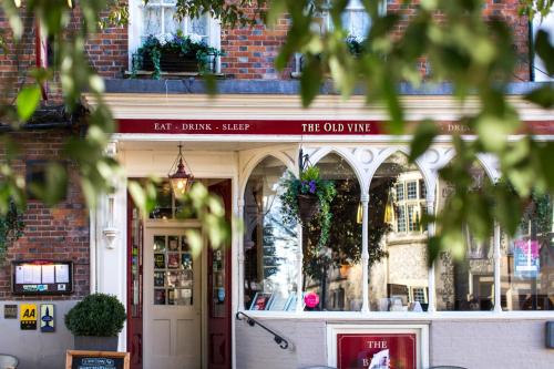 um edifício com um sinal que lê o velho vinho em The Old Vine em Winchester