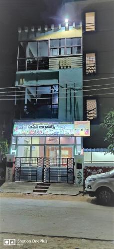a building on a street with a car parked in front at Jayaram Residency Tirupathi in Tirupati