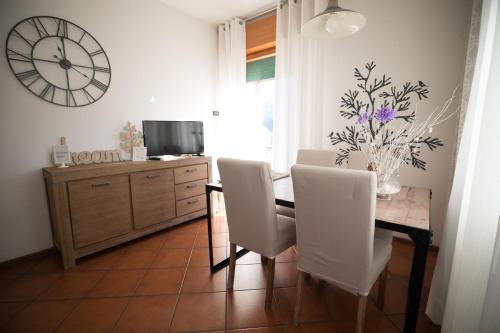 a dining room with a table and chairs and a clock at Dolomiti in Pieve di Cadore