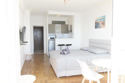 une chambre blanche avec un lit et une table dans l'établissement Promenade des anglais Vue mer, à Nice