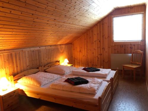two beds in a room with wooden walls at Ferienhaus Brittsbo in Ramvik